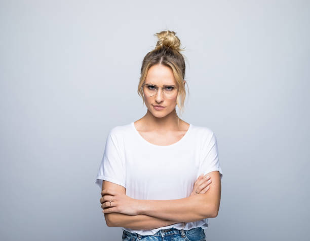 istock Confident blond woman standing with arms crossed 1387626446