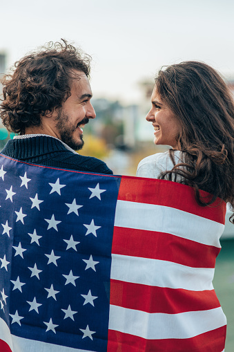 Happy couple wrapped in American flag