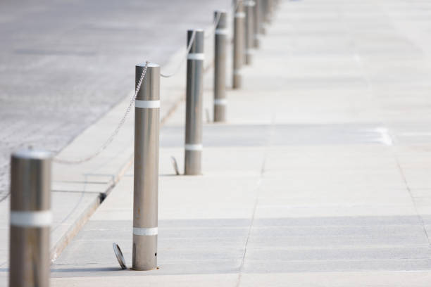 istock stainless steel bollards with chain on footpath. silver metal bollards. 1387627509