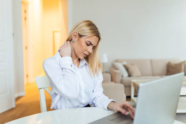 istock Feeling exhausted. Frustrated young woman looking exhausted while sitting at her working place and carrying her glasses in hand 1387627576