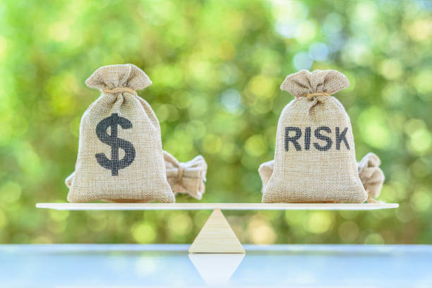 risk assessment / risk analysis and management concept : dollar and risk bags on a basic balance scale. - offense imagens e fotografias de stock