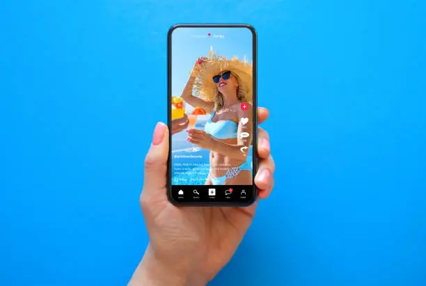 Photo of Mobile phone on blue background with shared video on sample social media app