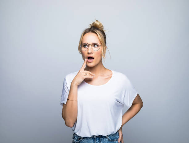 istock Surprised blond woman with hand on hip looking away 1387628667