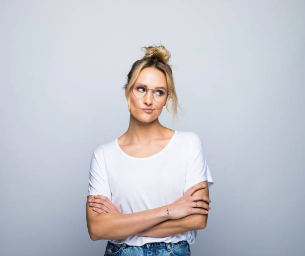 istock Thoughtful blond woman with arms crossed looking away 1387628743