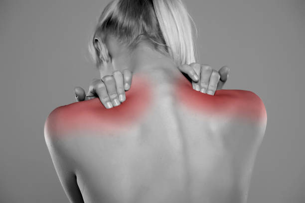 Young man, shirtless, scratching his back with his hands. Skin disease. Irritation, allergy. Isolated on black background.