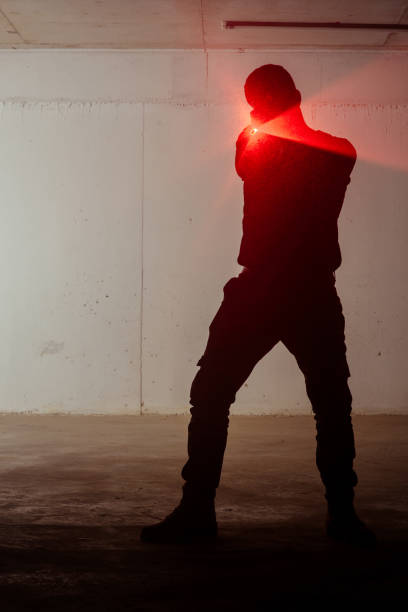 istock Silhouette of a man with laser gun 1387629475