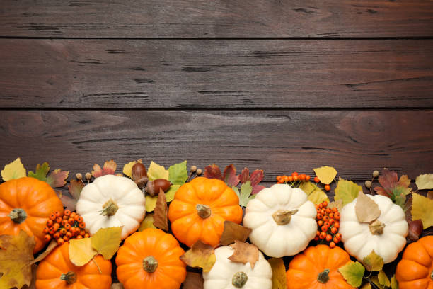 istock Flat lay composition with pumpkins and autumn leaves on wooden table. Space for text 1387629667