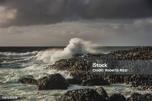 Ocean Waves Smashing On Hexagonal Rocks At The Giant S Causeway On A Murky Day Bushmills Northern Ireland Sea Wave Hitting A Cliff Convey A Strong Impact Or Big Effect Concept Bushmills County Antrim United Kingdom Stock Photo - Download Image Now