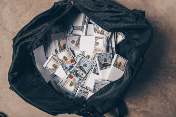Black bag full of money Bag full of money is standing on the floor bag of coins stock pictures, royalty-free photos & images