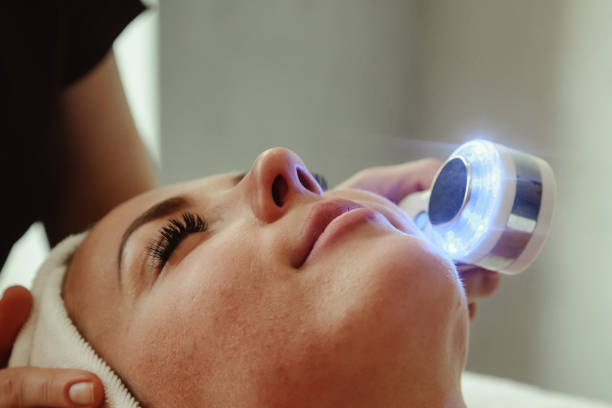 istock Beautician doing led light therapy to woman with problematic skin in SPA 1387630771