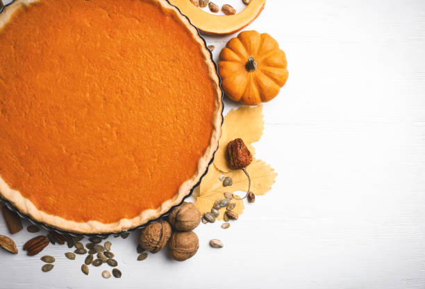 istock Flat lay composition with delicious homemade pumpkin pie on white wooden table. Space for text 1387630892
