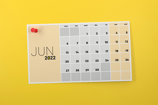 Página de calendario de junio de 2022 anclada sobre fondo amarillo photo