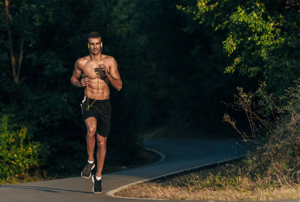 istock Young sportive man exercise running outdoors keeping fit at mountain road on sunset 1387631188