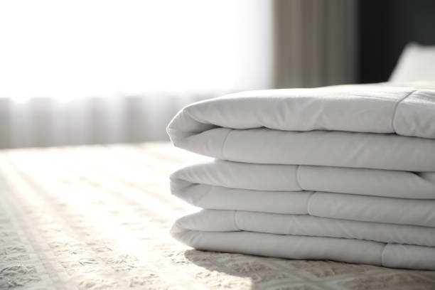 istock Folded clean blanket on bed in room, closeup. Space for text 1387631251