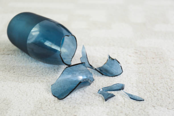 istock Broken blue glass vase on carpet, closeup 1387631257