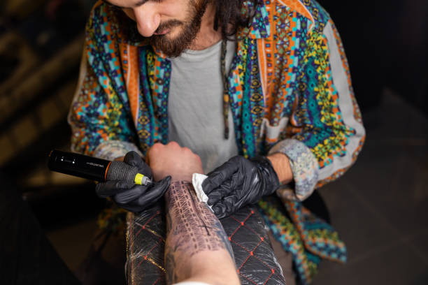 Man is tattooing a man's arm