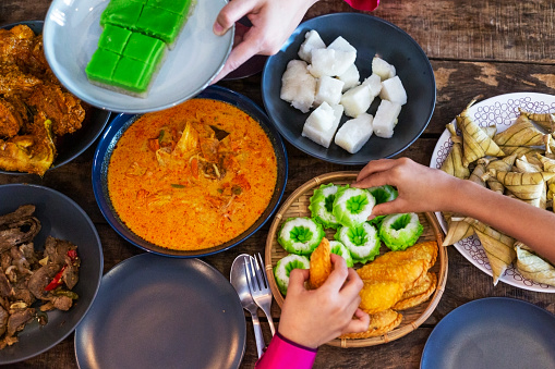 Breaking fast on Ramadan Hari Raya High angle view of malaysian Muslim family having family reunion meal assorted malay food at home celebrating hari raya