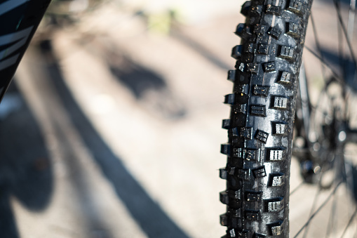 Black trail rubber tyre on a mountain bike close up detail