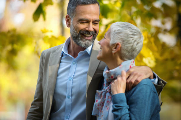 istock Mature couple walking through a park. 1387637501