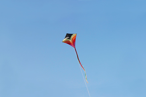 Colorful kite flying in a clear blue sky