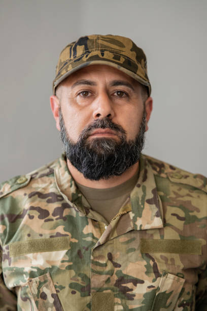 male veteran soldier with beard and military suit, looking at the camera, vertical photo male veteran soldier with beard and military suit, looking at the camera, vertical photo soldier grave stock pictures, royalty-free photos & images