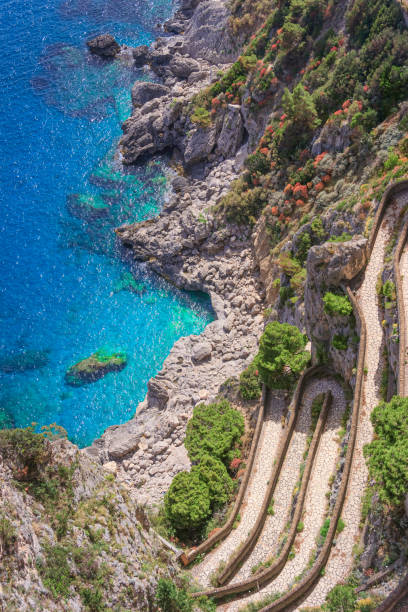 View of Via Krupp from Gardens of Augustus descending to Marina Piccola sea, Capri Island, Italy. View of Via Krupp from Gardens of Augustus descending to Marina Piccola sea, Capri Island, Italy: it is a historic paved footpath connecting the Charterhouse of San Giacomo and the Gardens of Augustus area with Marina Piccola. via krupp stock pictures, royalty-free photos & images