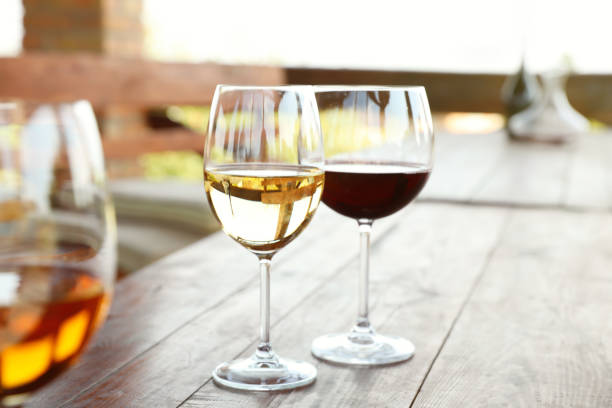 glasses with different wines on wooden table in outdoor cafe - white wine wine white glass imagens e fotografias de stock