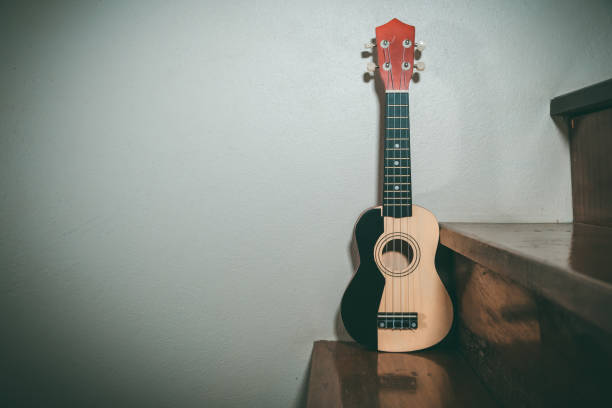 istock The ukulele is positioned against a white backdrop to see the ukulele shadow from the old wooden floor. 1387640107