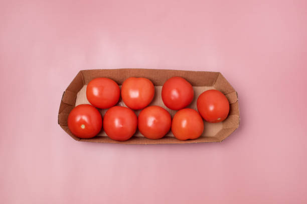 istock Small Red Tomatoes on Paper Basket on Pink Background Vegetable Horizontal 1387641177
