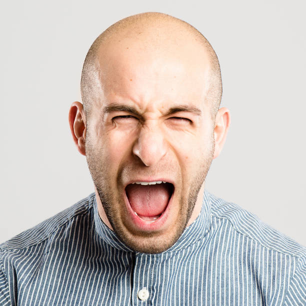 istock Shot of a handsome young man standing alone in the studio and screaming 1387643367