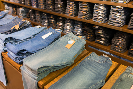 Folded men's jeans on a shelf in a clothing store