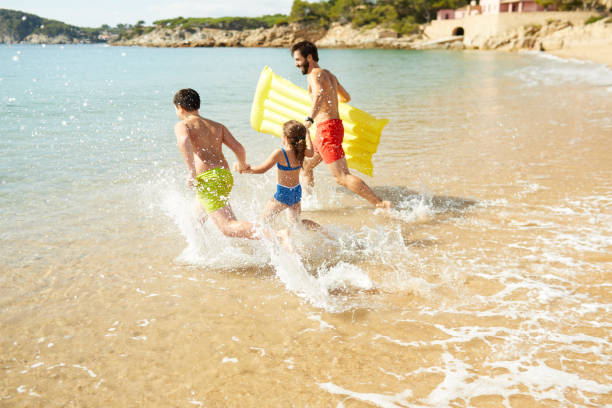 istock A father with his two children is on vacation at the beach. 1387646640