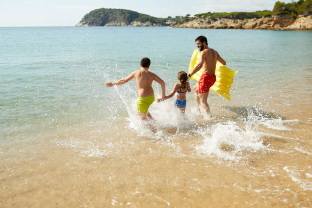 istock A father with his two children is on vacation at the beach. 1387646662