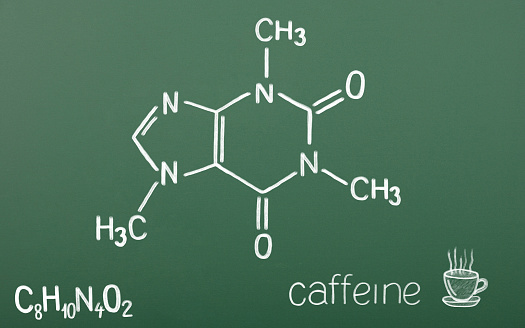 Chemical structural formula of caffeine drawn on chalkboard.\nIsolated on schoolboard background