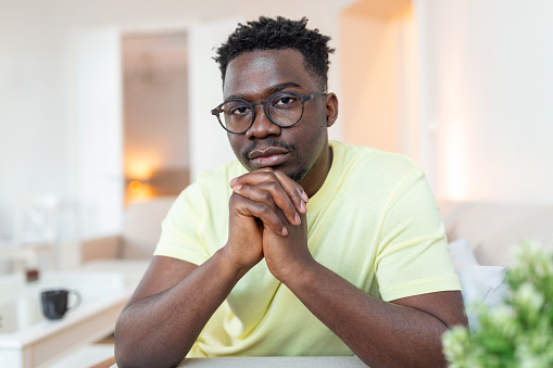 Close up profile view of pensive upset African American man look in distance thinking of personal problems, thoughtful sad biracial male feel depressed lost in thoughts pondering, having dilemma