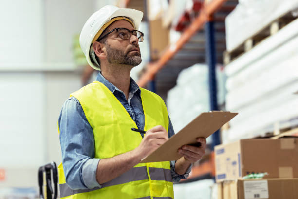 istock Mature worker passing list of material that has arrived at the store warehouse. 1387652026