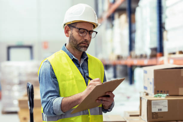 istock Mature worker passing list of material that has arrived at the store warehouse. 1387652051