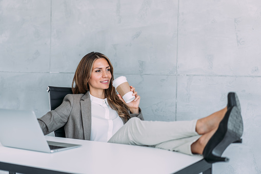 Young businesswoman relaxing with her feet on the desk.