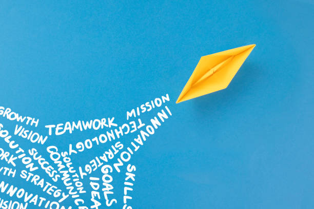 istock Paper Boat on Blue Background with Business Related Words 1387653373