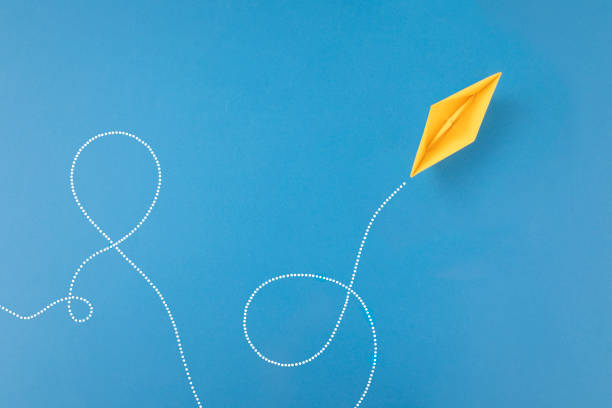 istock Yellow Paper Boat on Blue Background 1387653723