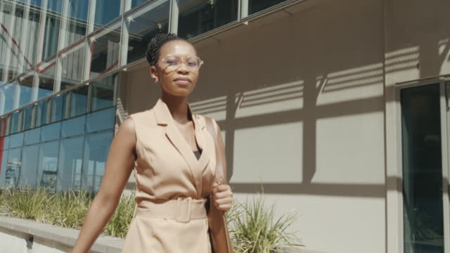 4k video footage of a young businesswoman walking through the city