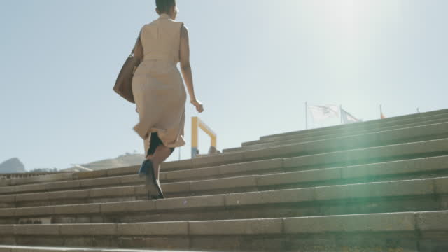 4k video footage of a businesswoman walking up a flight of stairs in the city