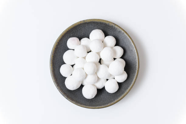 istock White sugar balls in a gray ceramic plate on a white background. Close up top view. 1387655132