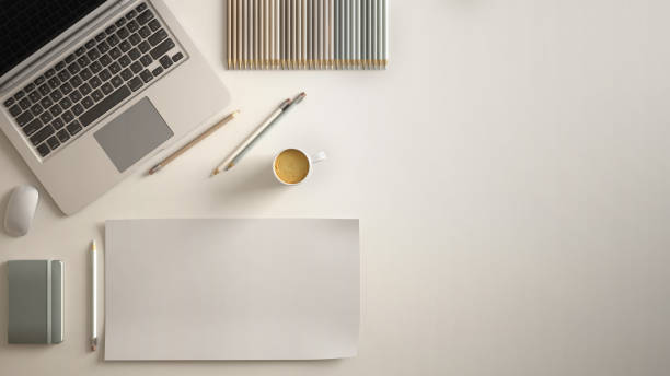 Stylish minimal office table desk. Workspace with laptop, notebook, pencils, coffee cup and sample color palette on white background. Flat lay, top view, blank paper mockup template