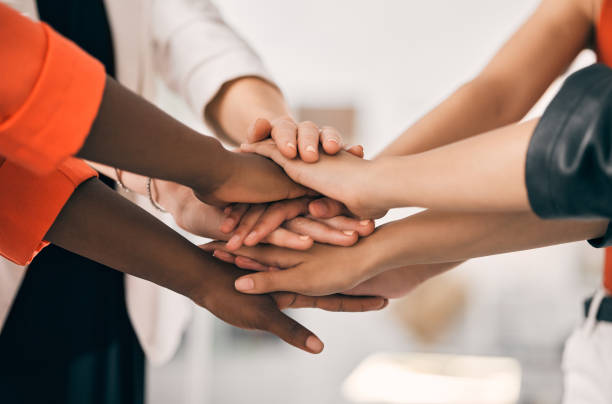 istock Shot of a group of unrecognizable businesspeople stacking their hands at work 1387657712