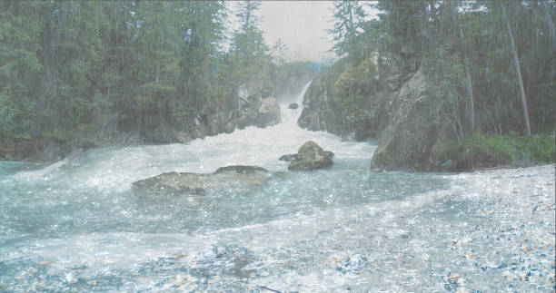The heavy rain falls into a strong flowing waterfall in the rainforest