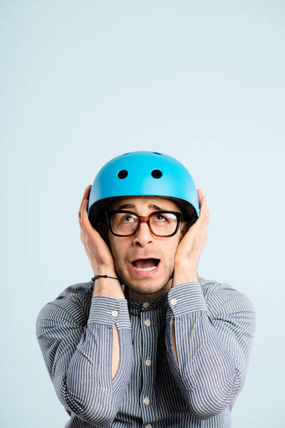 istock Shot of a handsome young man sitting alone in the studio and looking scared while wearing a helmet 1387657985