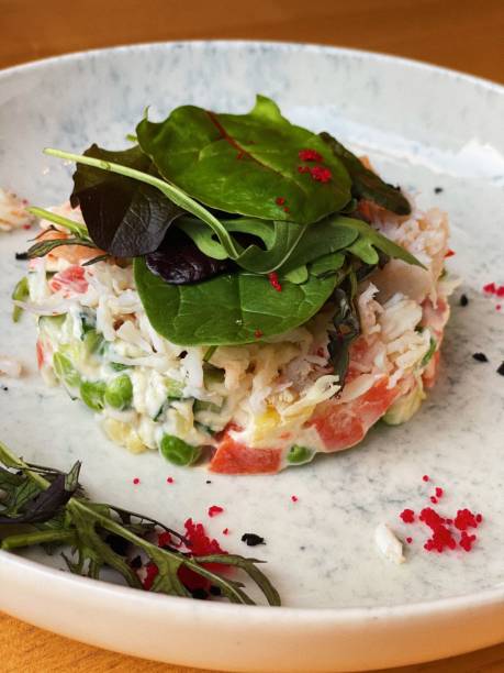 Olivier salad with crab meat and capers stock photo