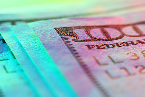 Hundred dollar bill in abstract lighting, close-up.