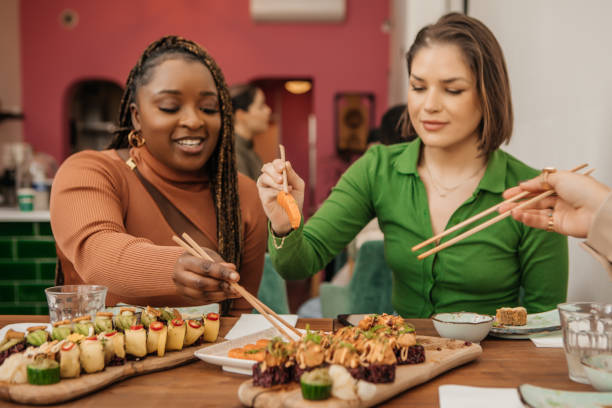 friends enjoying sharing vegan sushi in a local restaurant - buffet japanese cuisine lifestyles ready to eat imagens e fotografias de stock